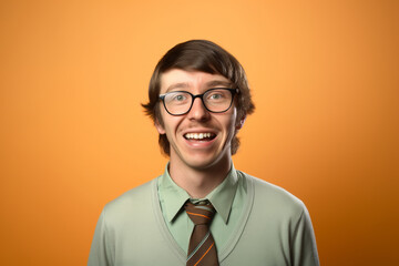 Wall Mural - Happy young man with glasses and mustache in business casual attire, posing against an orange background