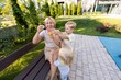 © Ivan Traimak - Mother Enjoys Playtime With Her Two Sons in a Sunny Playground Setting