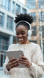 © alfa27 - A woman wearing headphones and holding a tablet