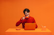 © Jacob Lund - Entrepreneur enjoying coffee in vibrant monochromatic office setting with bold orange tones and stylish design