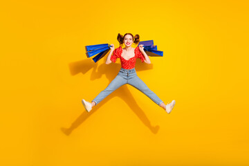 Canvas Print - Full body photo of attractive young woman hold shopping bags jump excited dressed red retro clothes isolated on yellow color background