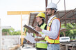 © amorn - Team of male engineer construction working and inspecting structure of building at construction site. Two male construction builder working at construction site