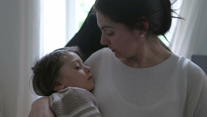 Mother kissing her child on the forehead, comforting him after he got hurt in the head, showing a tender and caring expression, capturing a heartwarming and intimate moment of maternal love