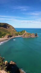 Wall Mural - aerial reveal of scenic coastline of piha black sand beach in west auckland. huge rock feature appea