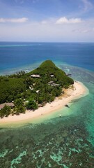 Wall Mural - aerial view over remote fijian village and resort on small pacific island covered in white sand, pal