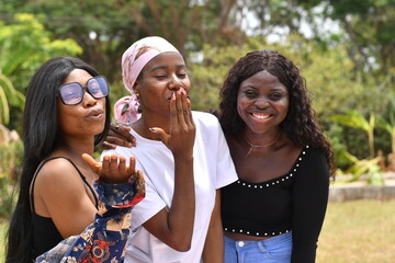 young beautiful african ladies taking a stroll in a garden having happy discussion