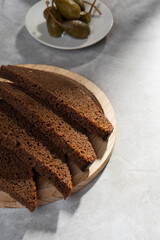 Wall Mural - Black rye bread is cut into portions and lies on a wooden plate