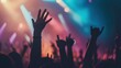 © Iswanto - Silhouettes of crowd hands raised at a concert with colorful lights.