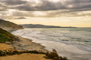 Wall Mural - 2024-01-10 A VIEW OF THE ROCKY CLIFFS ALONG THE BEACH AT TORREY PINES STATE PARK AND THE PACIFIC OCEAN WITH LA JOLLA IN HTE DISTANCE AND A CLOUDY SKY