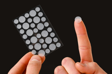 skin care with acne pimple patches on black background. easy way to get rid of problematic zits on i