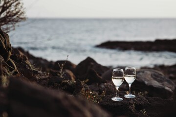 Two glasses of white vine on stones