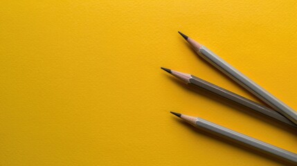 Two pencils on yellow background top view