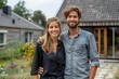 © Yuliia - young couple standing in front of their new home, smiling with excitement and happiness. The modern, stylish house is nestled in a cozy neighborhood with a spacious garden