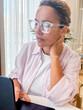 © simona - Focused middle aged woman holding document and using laptop at home. Female adult worker checking life insurance or savings financial account, paying bill on bank online app, planning budget