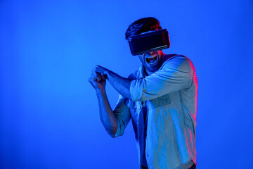 Caucasian man wearing VR glass and moving gesture holding sword. Gamer using future digital virtual reality headset or futuristic innovation to enter meta world or playing action game. Deviation.