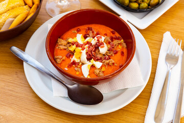 Porra antequerana, traditional spanish appetizer, puree consisting of tomato and bread served with canned tuna, sliced ham and boiled egg