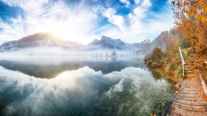 Wall Mural - captivating autumn scene of foggy and sunny morning on almsee lake.