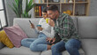 © Krakenimages.com - A man and woman relax on a sofa with coffee and a smartphone in a cozy living room setting.