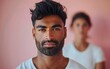 © imagineRbc - An athletic Indian male model poses confidently in front of a soft pink background, showcasing his expressive features and strong physique