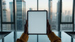 © Iana - African American man holding black tablet iPad Pro vertical with white blank screen, mockup, conference room with  glass table and urban cityscape view through the window