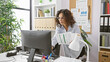 © Krakenimages.com - A professional hispanic woman reviewing documents in a modern office environment.
