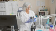 © Krakenimages.com - Mature woman scientist analyzing samples in a laboratory setting, with professional equipment indoors.