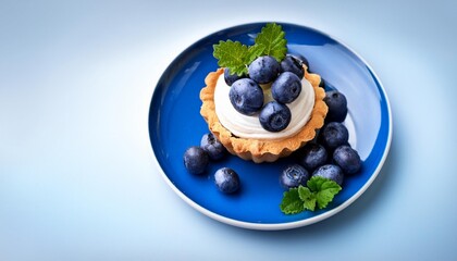 Poster - blueberry tartlet with cream on a blue plate