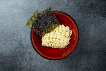 A bowl of instant noodles with seaweed on top