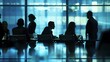 © Hoolity - Silhouetted business professionals engaged in discussions during a meeting in a modern office setting with a blue-tinted background.