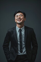 Poster - A man in a black suit and tie laughing