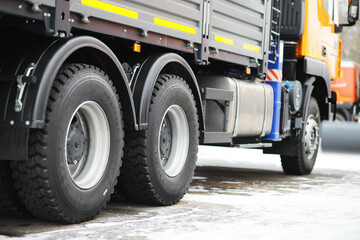 Close-Up of Heavy-Duty Truck Wheels on Snow-Covered Ground in Winter