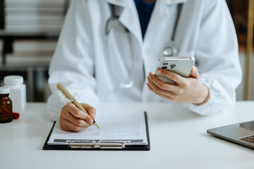 Medical technology concept. Doctor working with mobile phone and stethoscope and digital tablet laptop in modern office at hospital 