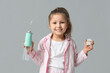 © Pixel-Shot - Cute little girl with oral irrigator and dental floss on grey background