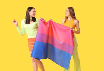 Poster - Beautiful young lesbian couple with Bisexual flag on yellow background