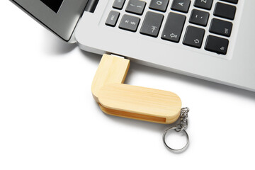 Poster - Modern laptop with wooden USB flash drive isolated on white background