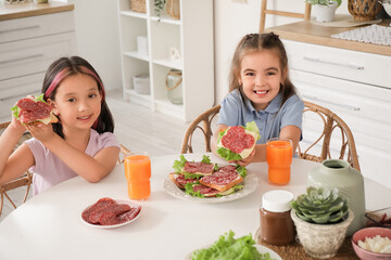 Wall Mural - Cute little girls with tasty toasts at table in kitchen