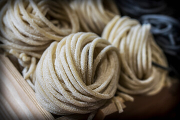 Decorative coils of white and black thin artisan pasta in a box