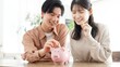 © mapo - 貯金箱にお金を入れるカップル