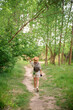 © Cristian Blázquez - Young woman enjoying nature while taking photographs on a lush forest path during daylight