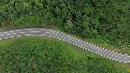 Canvas Print - Top view of a  car driving  dark green forest road, which is an elevated road that surrounds natural forest. Concept of using electric cars to protect the environment and transportation.