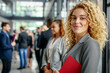 © Robert Kneschke - A diverse group of businesspeople standing in line and smiling in a modern office