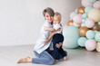 © Marharyta - Happy family, mother with her baby boy at home on his first birthday in the background of colorful balloons.
