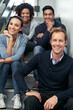 © peopleimages.com - Business, smile and portrait of team on steps in modern office building, creative collaboration and together. Multimedia production group, people and designers on stairs, task and project management.