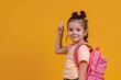 © Anna - A little girl with backpack doing thump up in her way back to school isolated solid bright color background