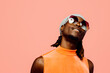 © Carlos David - Portrait of a happy young man with sunglasses and cap laughing, isolated on pink