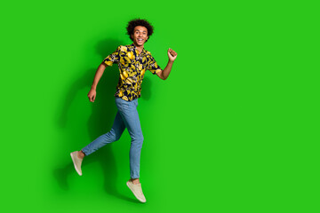 Sticker - Photo of cheerful positive glad man wear trendy summer print clothes walk empty space isolated on green color background