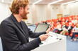 © Robert Kneschke - Smiling speaker discussing with audience during business event
