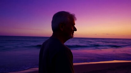 Wall Mural - A person silhouetted on the beach at sunset with the sea and waves in the background