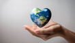 © anandart - The heart-shaped earth in the hands of a person, on a clean and clear background, conveys a message of global unity. concept of International Day of Peace