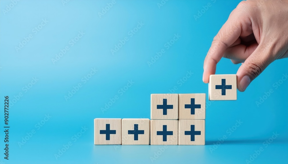 Value add concept. Hand place wooden cube with plus sign on light blue ...